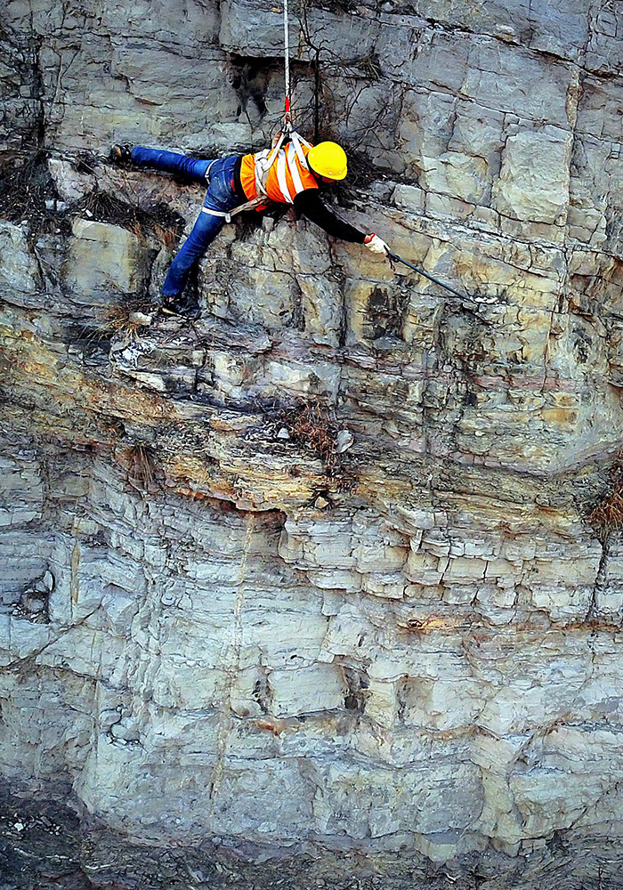 3月16日,一名捅山工贴伏在岩壁上,用撬棍检查