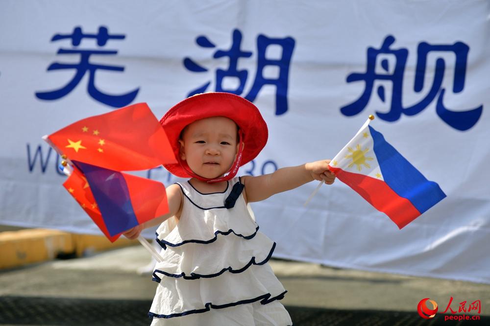 菲儿童在芜湖舰舷梯前挥舞着中菲两国小国旗。张海龙 摄