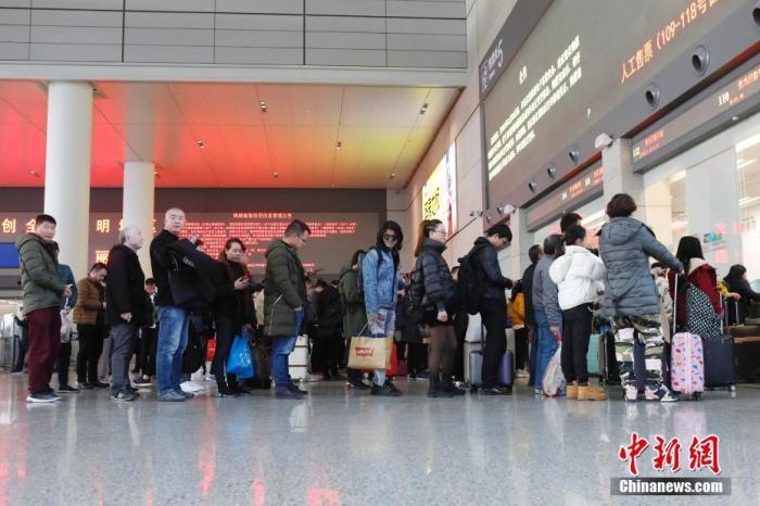 资料图：12月12日，旅客在铁路上海虹桥站排队购买车票。殷立勤 摄