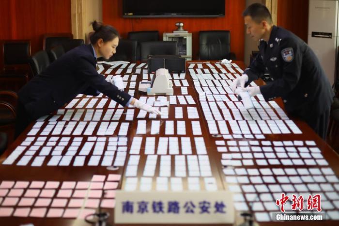资料图：12月10日，南京铁路公安处民警清点缴获的假火车票。中新社记者 泱波 摄