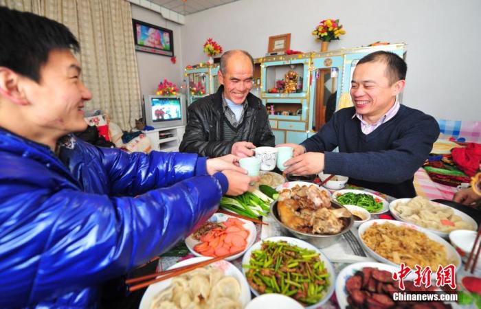 "资料图：辽宁省葫芦岛市民在家中与家人享受丰盛的年夜饭。<a