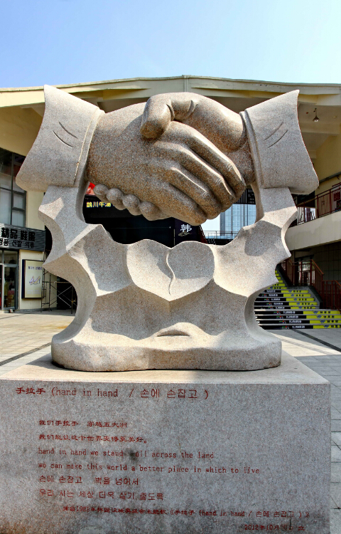 威海韩乐坊的巨大手拉手雕塑-预示中韩两国的友谊与合作-鞠传江摄影