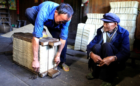 坐在一旁吸烟的邓雄绍老人用一种满意的目光看着儿子邓汉富手脚麻利地干活。