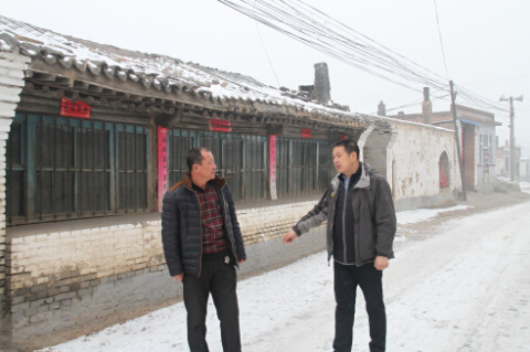 丁龙广与村主任现场讨论工作。