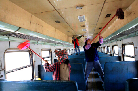 几位清洁工正在清理废弃列车的车厢，为装修“火车餐厅”做准备。