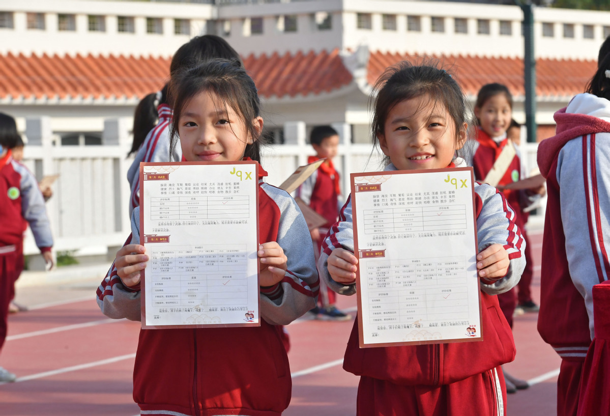 1月12日，在福建省泉州书泉港区后龙中心小学，两名孩子在展示自己闯关考核成绩单。1