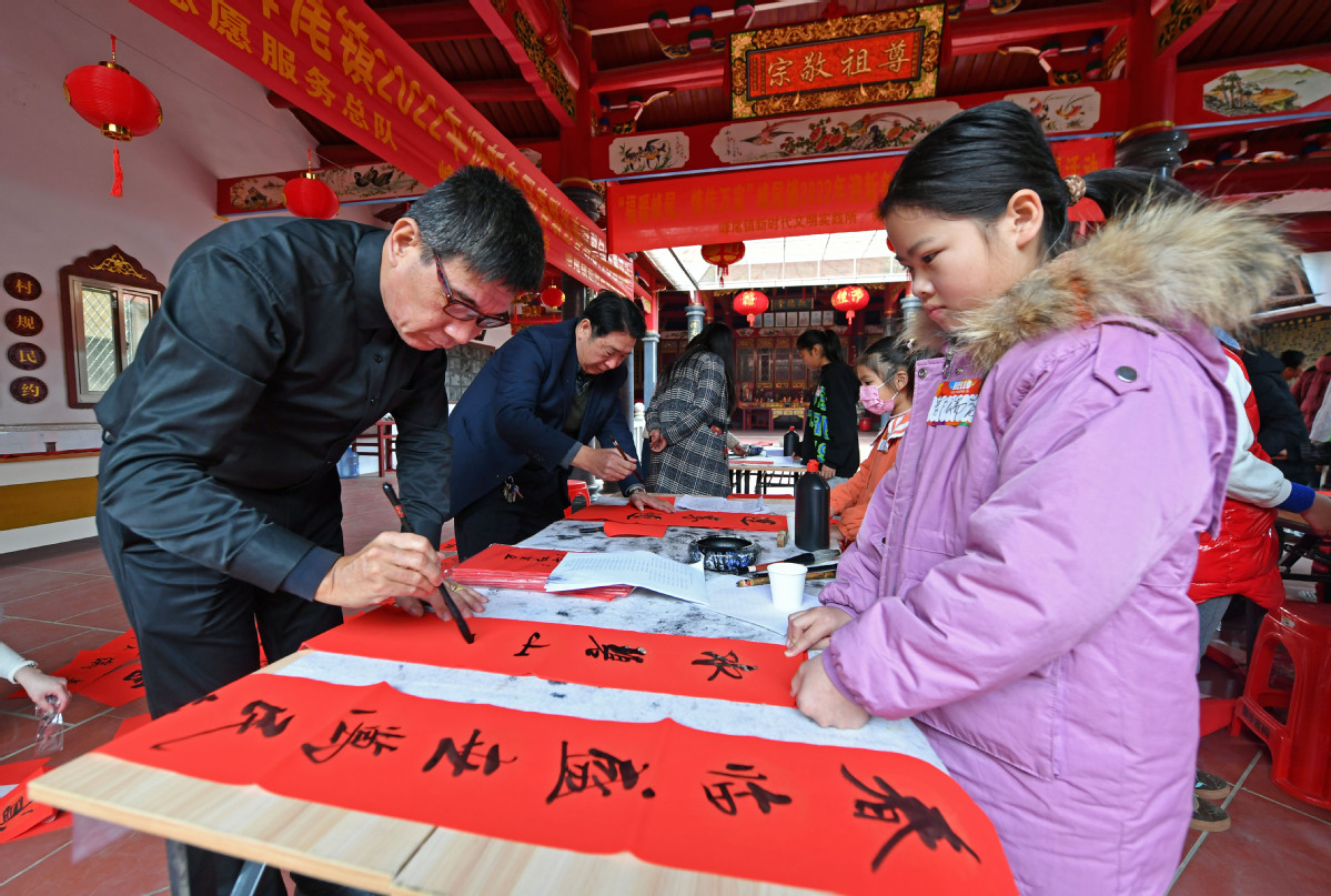 1月18日，在福建省泉州市泉港区峰尾镇郭厝村，书法爱好者在为村民义务写春联、送祝福。