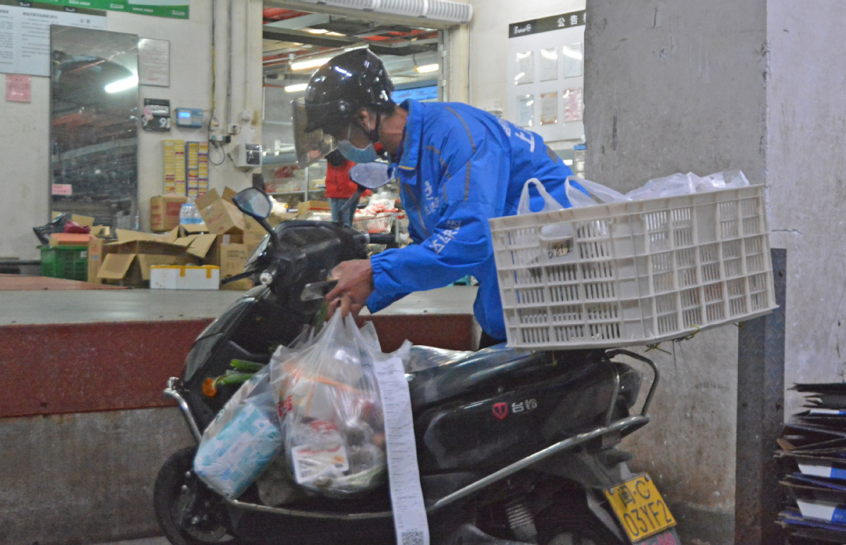 3月19日，在福建省泉州市泉港区永辉电商线上平台出货区，一名小哥把领的取订单货物装上车，准备配送。2