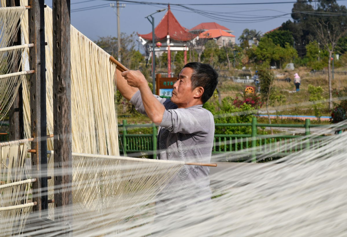 3月16日，在泉港区南埔镇凤翔村，寿面制作人正在晾晒寿面。洪坤泽摄
