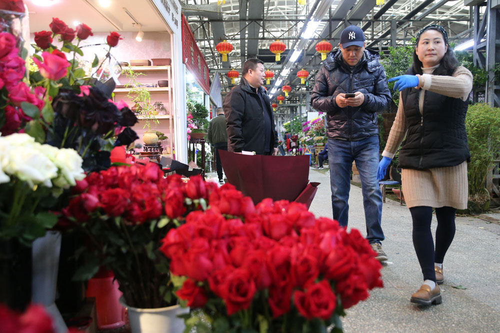 2月14日,北京莱太花卉市场,商家为顾客挑选玫瑰