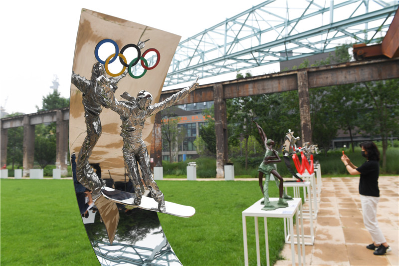7月13日，参观者在拍摄展出的雕塑作品。