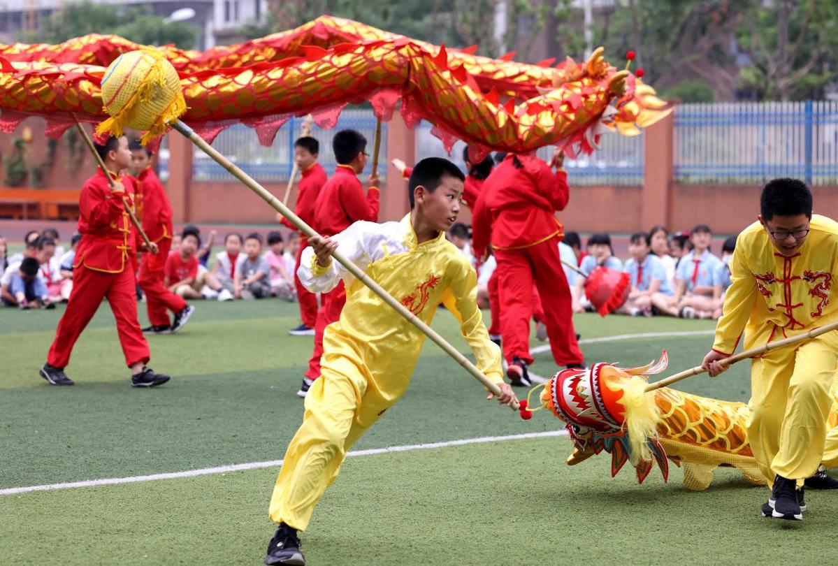 2021年6月10日,在合肥市瑶海区蚌埠路第二小学,孩子们在进行传统舞龙