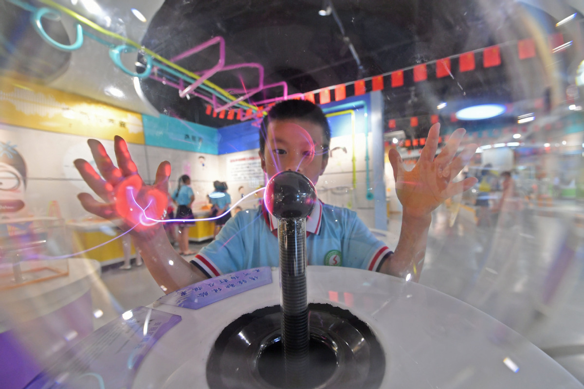 2021年7月6日，在福建省泉州市泉港区科技馆，一名学生在体验科普教具——辉光球。