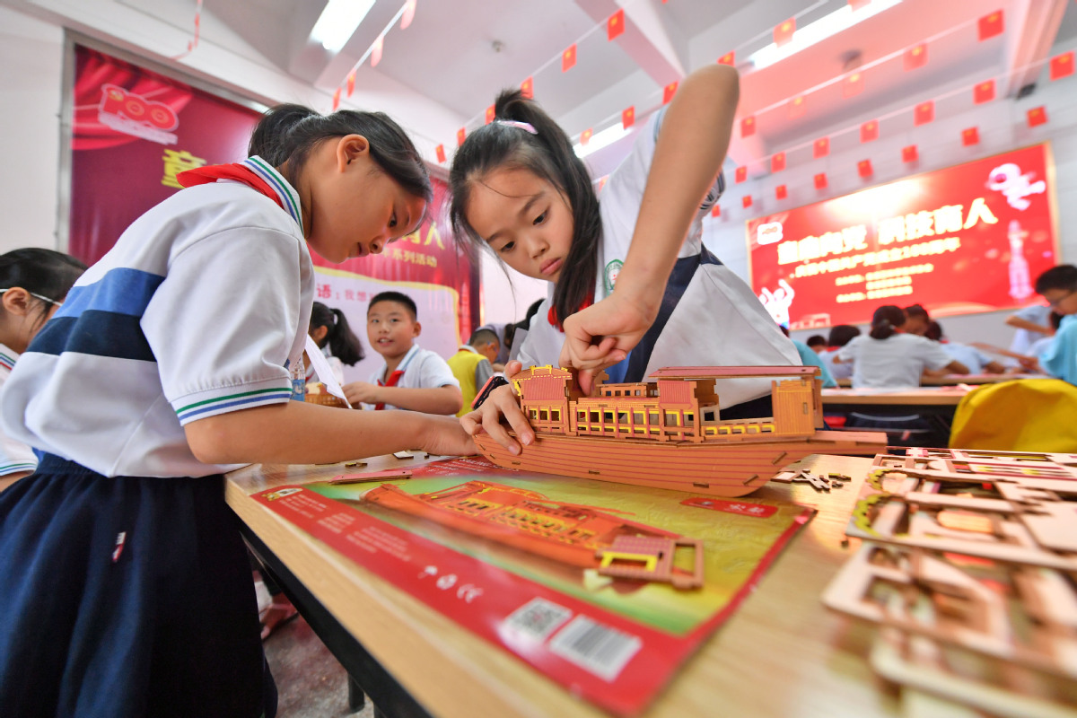 2021年7月6日，在福建省泉州市泉港区科技馆，两名学生在拼装南湖红船模型。3